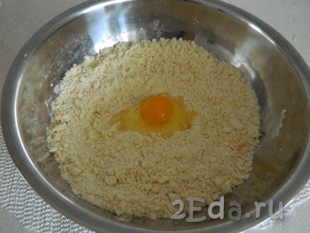 Затем к получившейся крошке добавляем яйцо и замешиваем тесто. Если вдруг одного яйца мало и тесто не собирается в комок, можно добавить ещё одно яйцо.
