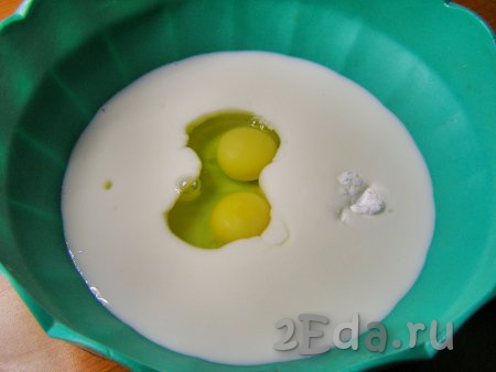 Кефир переливаем в глубокую миску, добавляем два яйца, соду и соль, хорошо перемешиваем венчиком, чтобы масса стала однородной.