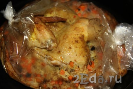 Запекать курицу с рисом в разогретой духовке при температуре 200 градусов 1 час. Готовую курочку с рисом достать из духовки и аккуратно разрезать рукав для запекания.
