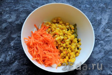В салатник к огурцам и яйцам добавить очищенную и натёртую на крупной тёрке свежую морковь, сюда же выложить консервированную кукурузу без жидкости.