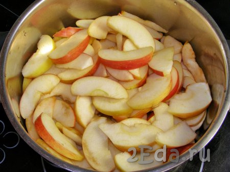 Разрезаем яблоки сначала на 4 части, вырезаем из них сердцевины, затем нарезаем каждую часть на дольки, примерно, 0,5-0,7 см толщиной. Кладём получившиеся яблочные дольки в кастрюлю с толстым дном.