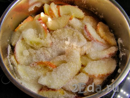 Наливаем в кастрюлю 50 мл воды, насыпаем сахар и встряхиваем кастрюлю, чтобы сахар равномерно распределился по яблочным долькам.