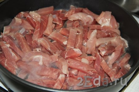 Свинину нарезать на брусочки. Влить немного растительного масла в сковороду, поставить на огонь и разогреть, а затем выложить свинину, нарезанную брусочками.