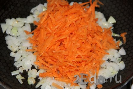 К обжаренному луку выложить морковку, натёртую на крупной тёрке.