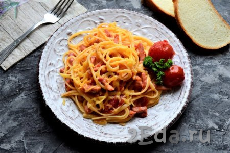 Очень вкусные спагетти, приготовленные с колбасой и сыром, немного перемешать, разложить по тарелкам и подать к столу.