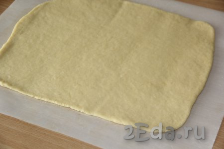 По прошествии времени на пергаменте раскатать тесто в прямоугольный пласт толщиной, примерно, 0,5-0,7 см.