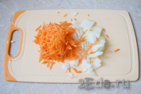 В это время займитесь оставшимися овощами. Лук и морковь очистите и ополосните. Мелко нарежьте луковицу, а морковку натрите на тёрке.