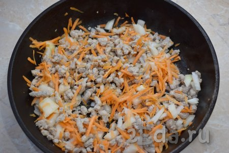 К обжаренному фаршу добавьте лук и морковь, обжаривайте их вместе, помешивая, ещё 3-4 минуты.
