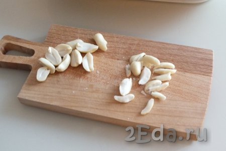 Очищенный арахис разрежьте ножом вдоль ядрышка на продолговатые кусочки.
