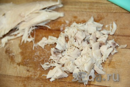 Нанести сеточку из майонеза поверх картошки. Куриное филе сварить в течение 20-25 минут с момента закипания, затем остудить в бульоне. Нарезать остывшее мясо на мелкие кубики.