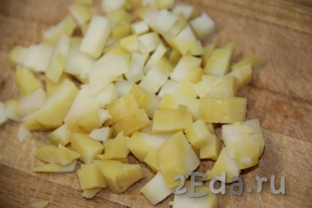 Картофель предварительно сварить в мундире (на варку понадобится минут 20-25 с начала кипения воды), затем слить воду, остудить, очистить клубни от кожуры и нарезать на мелкие кубики.