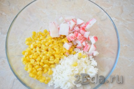 Крабовые палочки необходимо заранее разморозить. Затем нарежьте их на небольшие кусочки и добавьте в салат из риса и кукурузы.