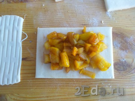 На основу слоек выложить остывшую яблочную начинку. Яйцо аккуратно разделить на белок и желток. Белком смазать края теста (белок мы используем для склеивания частей теста).