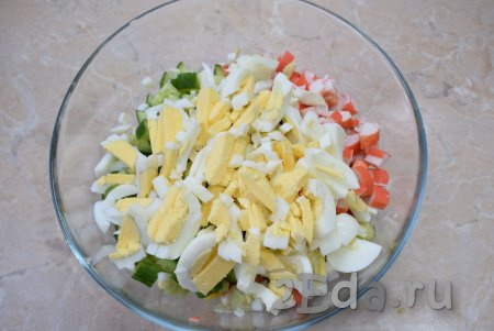 Варёные яйца очистите от скорлупы, некрупно нарежьте и выложите в салат из пекинской капусты, свежего огурчика, крабовых палочек и кукурузы.