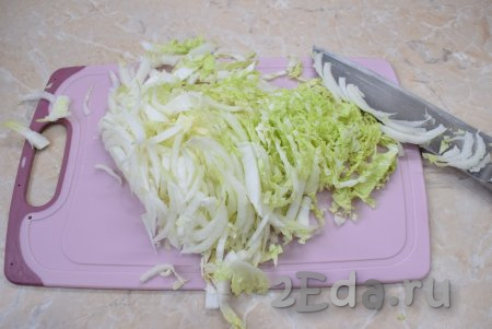 Пекинскую капусту тонко нашинкуйте и переложите в глубокий салатник, в которой будете готовить салат.