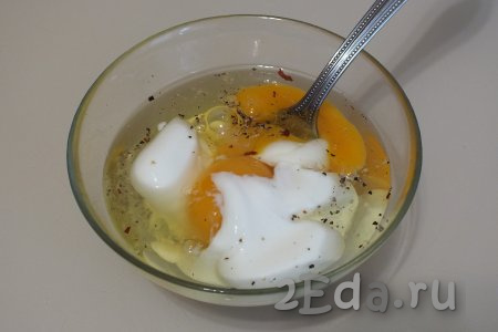 Сделайте заливку для запеканки, для этого сырые яйца, сметану, соль и специи хорошо перемешайте с помощью вилки.