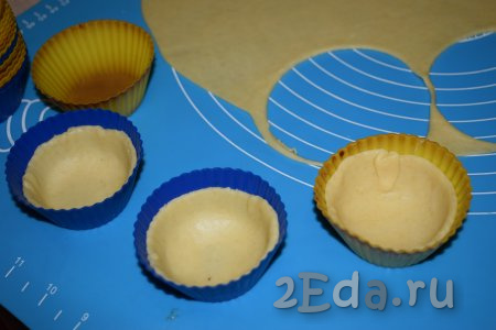 Силиконовые формочки для кексов смазываем растительным маслом и кладём внутрь вырезанные кружочки, формируя бортики. Выход по данному рецепту 26 корзиночек.