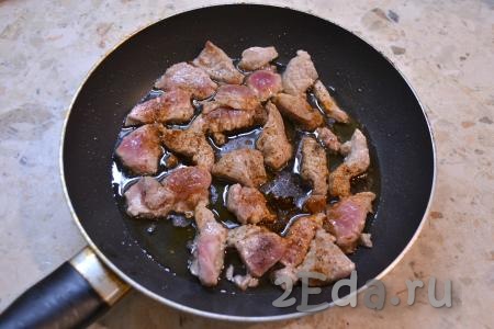 Сковороду разогреть с растительным маслом, выложить свинину, посыпать специями, влить соевый соус.