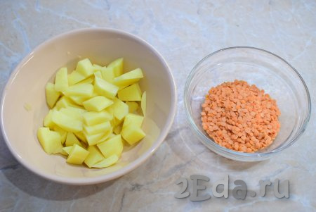 Для супа подготовьте картофель и чечевицу. Картофель очистите, промойте и нарежьте небольшими кусочками. Опустите нарезанный картофель в кипящий бульон (или воду) и варите минут 10 (до полуготовности). Красную чечевицу можно предварительно не замачивать, её достаточно будет просто промыть. 