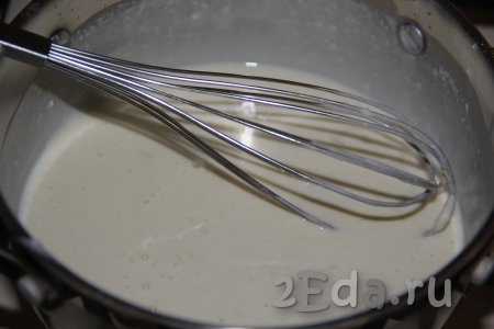 Затем добавлять молоко маленькими порциями и тщательно перемешивать венчиком.