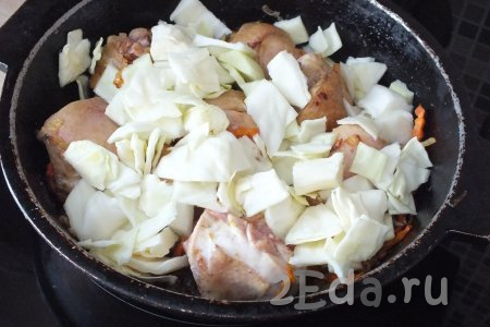 К обжаренной курице добавьте капусту, перемешайте, обжарьте в течение 5 минут, после влейте 100 мл воды, дайте закипеть. Накройте сковороду крышкой, сделайте огонь чуть ниже среднего и тушите 15-20 минут.