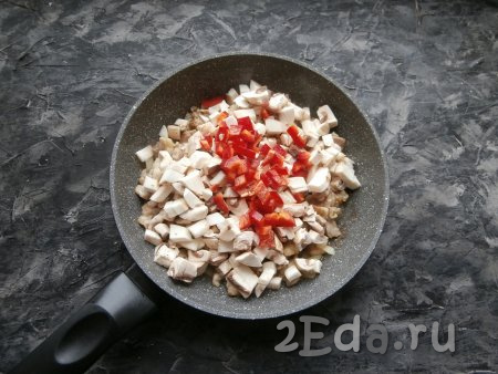 Обжарить куриное мясо с луком на среднем огне до изменения цвета курицы и мягкости лука, добавить грибы и нарезанный маленькими квадратиками болгарский перец.