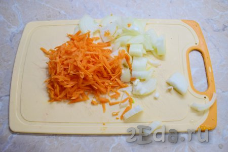 Пока крылья обжариваются, подготовьте овощи. Лук и морковь очистите от кожуры и ополосните. Затем лук мелко нарежьте, а морковь натрите на крупной тёрке.