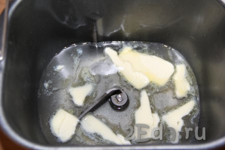 В ведёрко хлебопечки влить воду комнатной температуры и добавить кусочки мягкого сливочного масла. Всыпать соль и сахар.