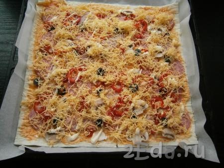 Оставшийся сыр натереть на средней или мелкой терке и щедро посыпать пиццу сверху.