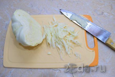 Для приготовления салата лучше выбирать более сочные сорта капусты. С кочана снимите 2-4 верхних листа. Отрежьте от кочана грамм 250 капусты, тонко нарежьте.