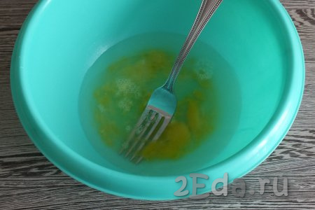 Приготовление пельменей начните с замешивания теста, для этого в миску разбейте яйцо, влейте воду, добавьте соль, перемешайте.