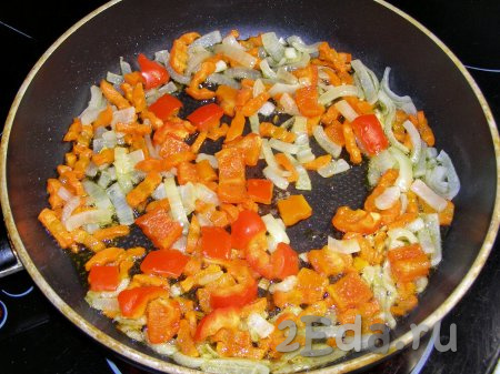 Затем к морковке с луком выкладываем кубики болгарского перца, перемешиваем и обжариваем ещё 3-4 минуты, не забывая помешивать время от времени.
