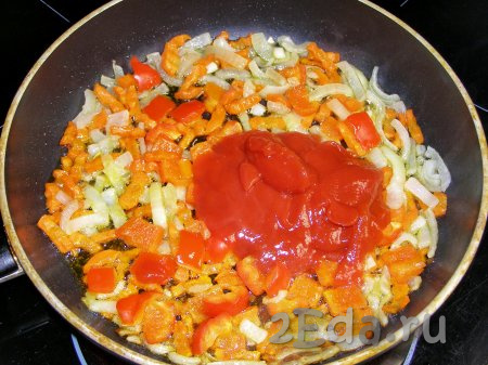 Кладём к обжаренным овощам томатную пасту и ещё раз хорошо перемешиваем.