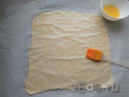 Каждую часть теста раскатать в тонкую лепёшку (толщиной не более 3 мм). Полностью смазать лепёшку растопленным сливочным маслом.