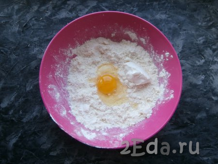 Перетереть получившуюся смесь руками в крошку, затем добавить одно сырое яйцо и сметану.