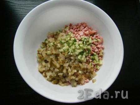 В салат из картошки и колбасы добавить свежий и маринованный огурчики, нарезанные маленькими кубиками.