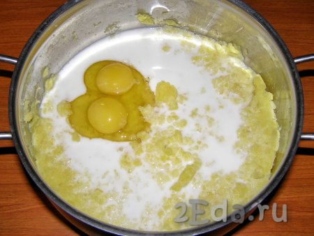 Когда картошка сварится, сливаем воду и разминаем картофель с помощью толкушки. Вливаем тёплое молоко (его нужно заранее разогреть на плите или в микроволновке), кладём в пюре яйца. Хорошо перемешиваем, чтобы пюре стало однородным и гладким (без комочков). Временно отставляем кастрюлю с картофельным пюре в сторону.