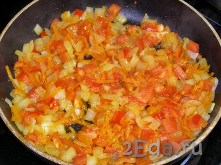 К луку, обжаренному с морковкой, добавляем кубики болгарского перца и помидора, перемешиваем и обжариваем всё вместе ещё 2-3 минуты. Не забывайте овощи в процессе обжаривания периодически перемешивать.