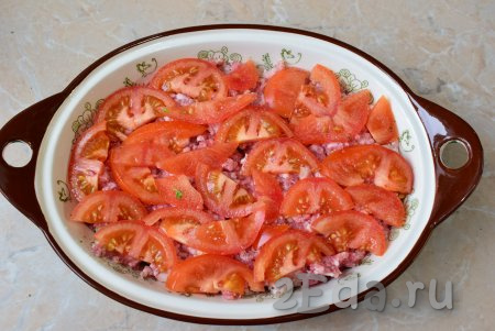 Помидоры помойте, разрежьте на две части и удалите плодоножки. Нарежьте помидоры тонкими ломтиками и выложите по всей поверхности мясного фарша. Немного посыпьте солью.