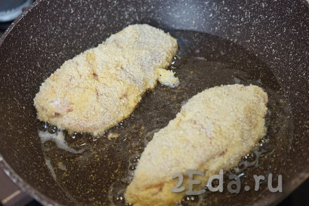 Наливаем на раскалённую сковороду 60 мл растительного масла и начинаем обжаривать куриное филе, фаршированное с ветчиной и сыром.