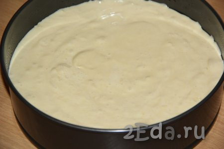 Для выпечки ванильного бисквита взять разъёмную форму диаметром 28 см, застелить её дно пергаментом. Выложить тесто и разровнять.