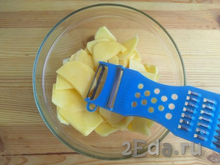 Картофель очистить от кожуры и промыть в проточной воде. Нарезать картошку тонкими ломтиками с помощью специальной тёрки (или нарезать ножом на тонкие дольки), промыть повторно.