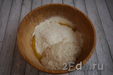 В миску с молочно-яичной смесью добавляем тёплое растопленное масло, запенившуюся дрожжевую смесь и, постепенно подсыпая 600 грамм муки, хорошенько вымешиваем тесто.