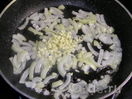 На другой сковороде на подсолнечном масле на среднем огне обжариваем лук вместе с чесноком, помешивая, в течение 3 минут (до мягкости).