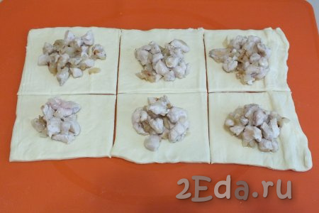 В центр каждого квадрата из слоёного теста выложите по 1 столовой ложке с горкой куриной начинки.