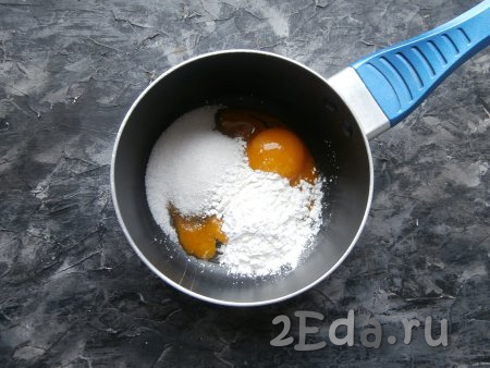 Вначале нужно приготовить заварной крем, для этого нужно 2 яичных желтка поместить в небольшую кастрюлю, добавить сахар, ванильный сахар и крахмал.