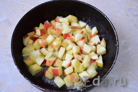 Добавьте яблоки и перемешайте содержимое сковороды. Тушите яблоки 5-7 минут на среднем огне, периодически помешивая. Сначала появится жидкость - это яблоки пустят сок, но в последствии вся жидкость выпарится.