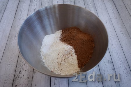 Начинаем приготовление торта "Вупи пай" с того, что замешиваем тесто, для этого в глубокую миску просеиваем 520 грамм муки, добавляем 150 грамм какао-порошка, 3 чайные ложки разрыхлителя, 1,5 чайные ложки соды, половину чайной ложки соли и 10 грамм ванильного сахара. Не пугайтесь, в этом рецепте, действительно, используется одновременно и сода, и разрыхлитель - это нормально. Помните, мы готовим большую печеньку, а она должна быть рассыпчатой.