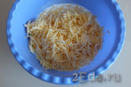 Натрите сыр на крупной тёрке, добавьте в миску с кефиром.