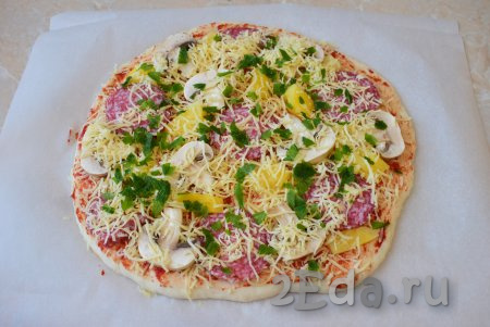 Посыпьте начинку отложенным натёртым сыром и измельчённой свежей зеленью. Духовку разогрейте до 180 градусов и отправьте пиццу в неё на 20-30 минут. Ориентируйтесь по своей духовке.
